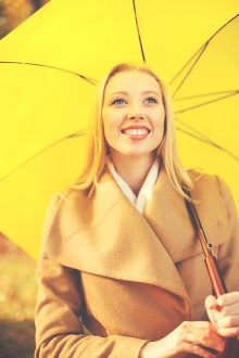 woman with yellow umbrella in the autumn park