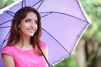 Beautiful young girl with umbrella outdoors