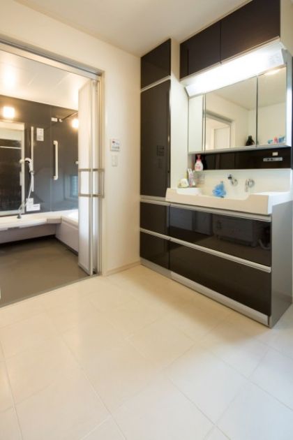車椅子での使用にも配慮し、浴室 と洗面の出入口はワイドに設計。 洗面もホワイト×ブラックを基調 色に、モダンな空間となった